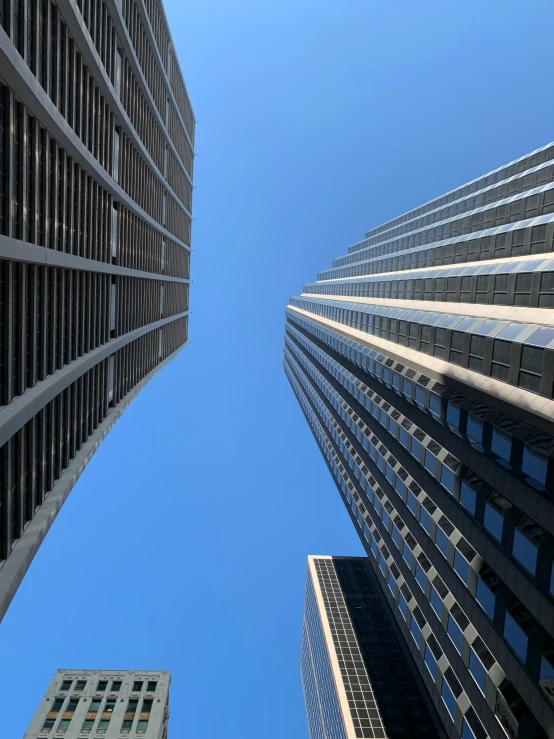 view from the ground of some buildings looking up at the blue sky