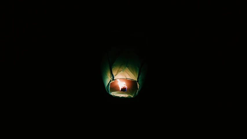 a person in the dark with a candle in their hand