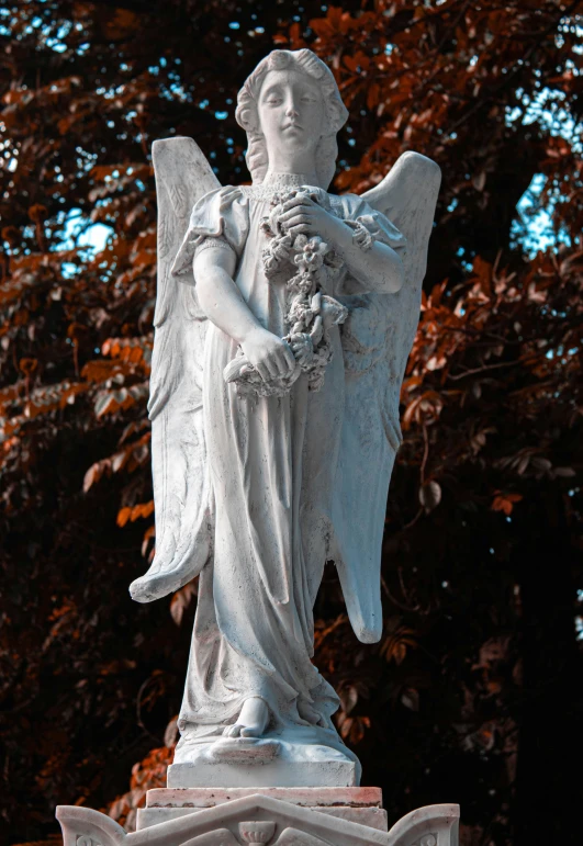 statue of an angel with flowers in it's hands