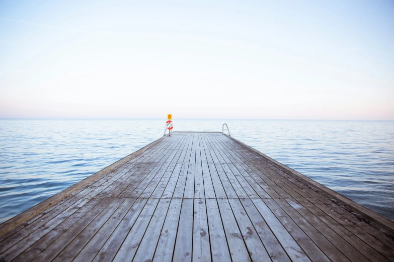 a long dock on the water with a stop sign