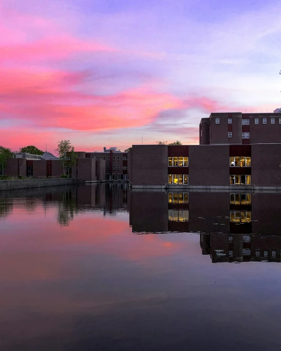 a sunset reflecting the building's lights in the water