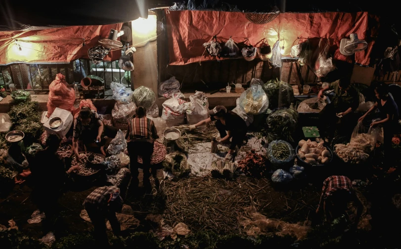 people sitting around in their tent setting near flowers and baskets