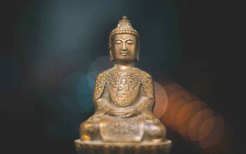 a buddha statue sits on top of a table