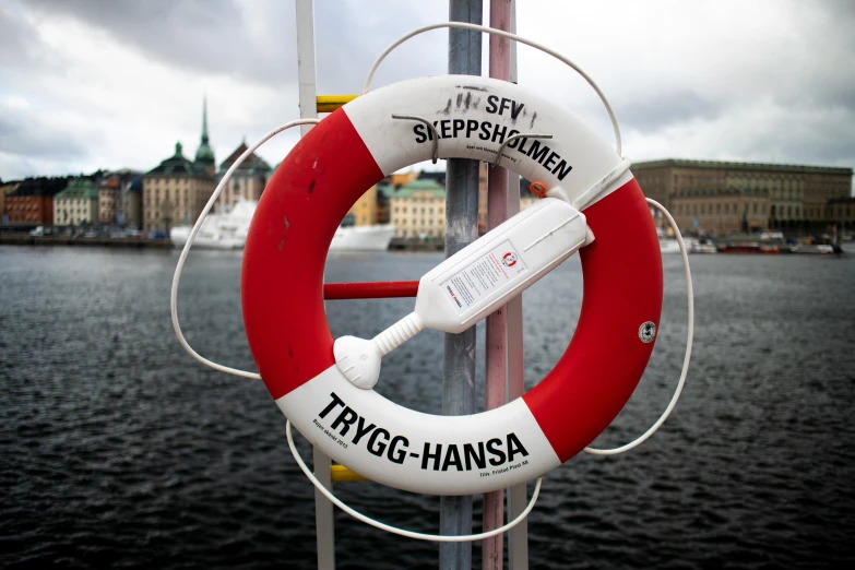 a lifesaver sits on a pole near the water