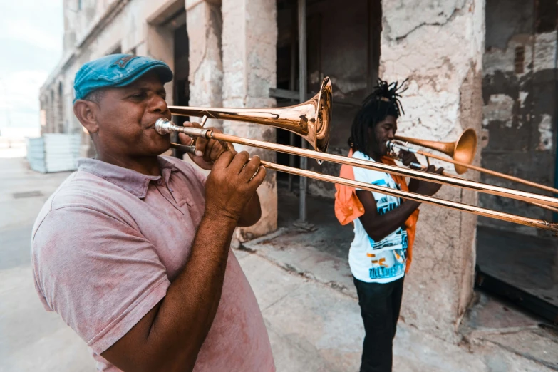 an image of a man playing ss horns with another woman in background