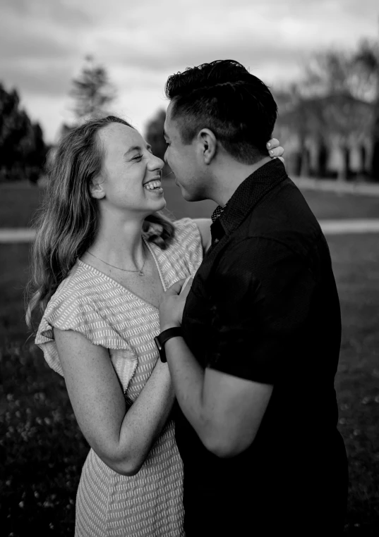 a couple cuddling on the grass at sunset