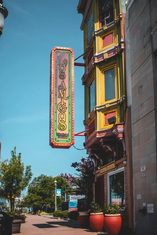 a colorful sign above a large building on a street