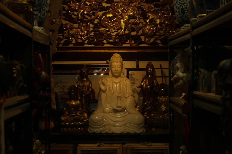 a statue in a room that has lots of decorations on the walls