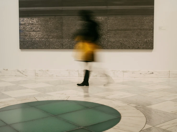 blurry pograph of woman walking through art exhibit