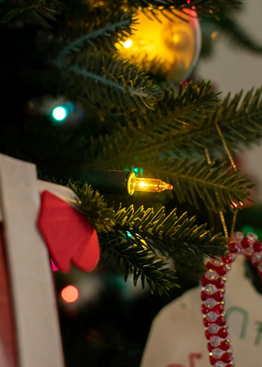 a lit christmas tree with a decorated ornament on it