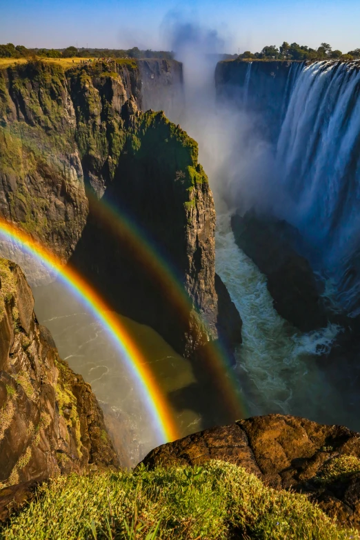 the two rainbows are shining bright above the water