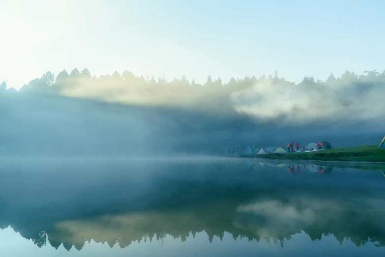 a fog covered body of water with boats on it