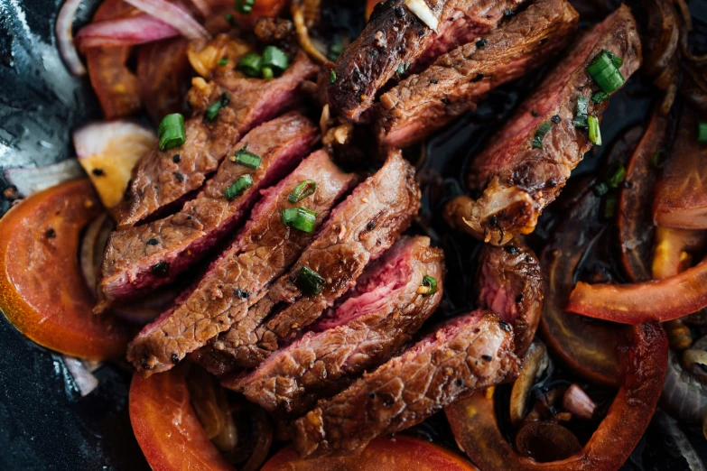 the steak, onions and peppers are next to the broth