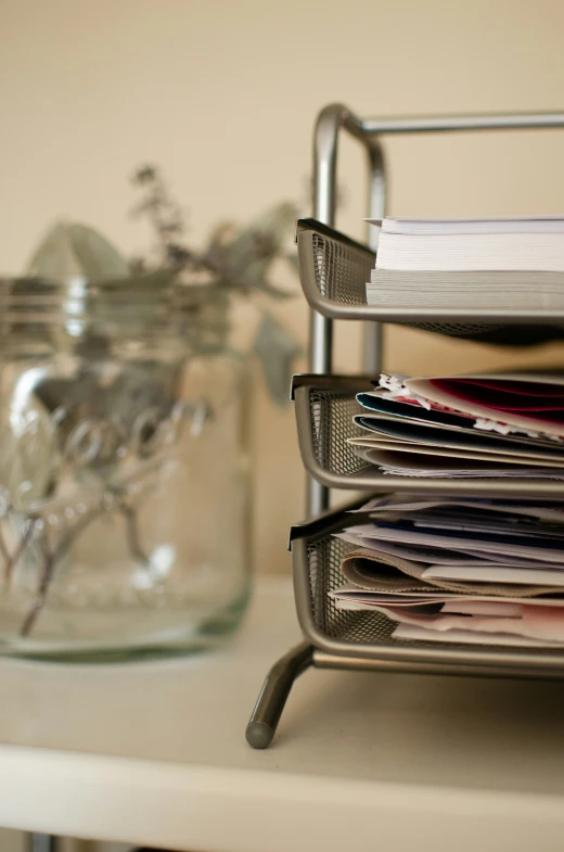 stacks of mail in a holder by a jar