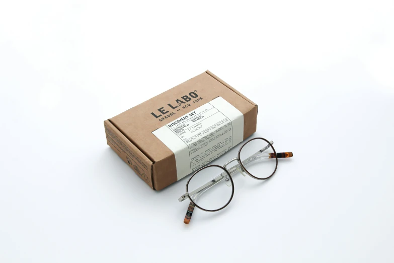 eyeglasses with an open box and case on a white surface