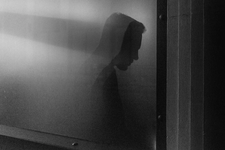 black and white pograph of a person hiding in the fog