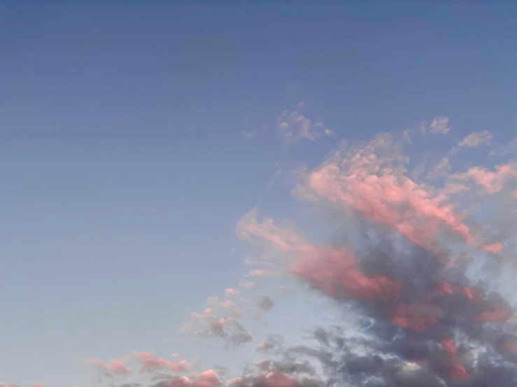 a pink cloud in the sky above some buildings