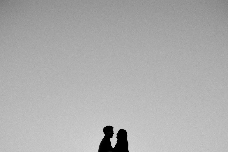 a man and a woman are silhouetted against the sky