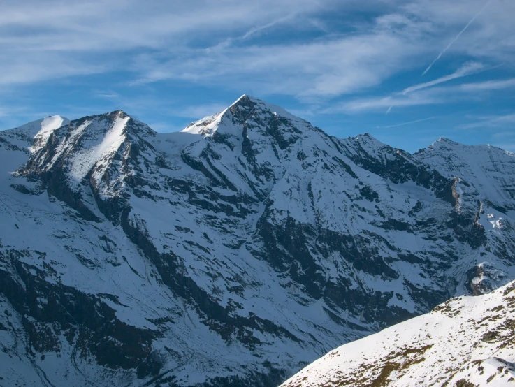 two skiers are seen on the top of a mountain