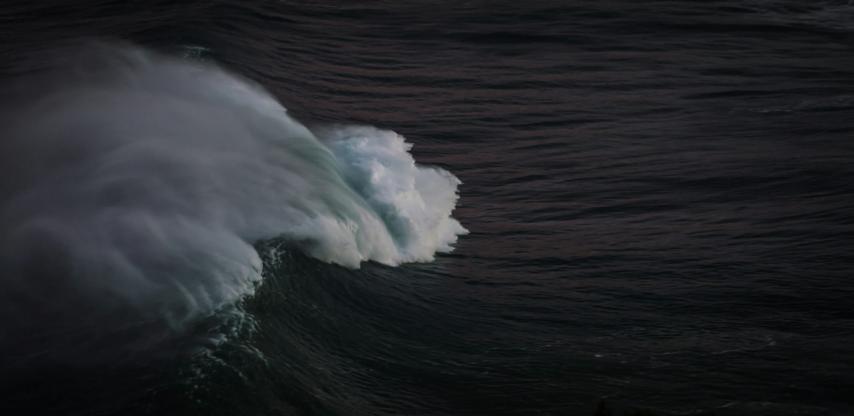 the image shows a massive wave breaking in on top of the waves