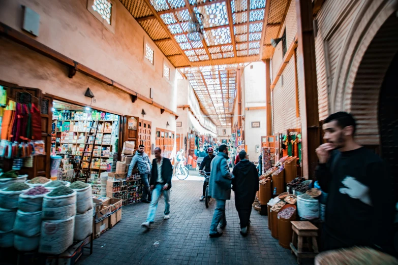 people shopping in an open market area with shelves full of goods