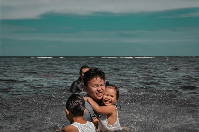 a woman holding a boy on her back, in the ocean