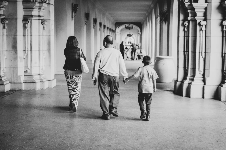 a man walking next to two children holding hands