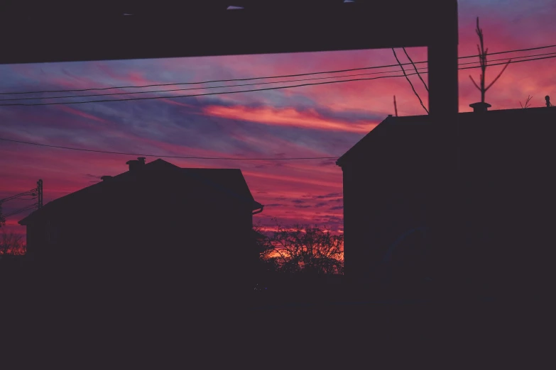 silhouette of a roof against a purple and blue sunset