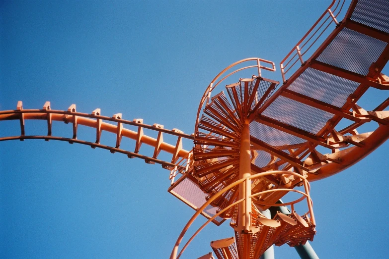 a roller coaster against a blue sky on a bright day