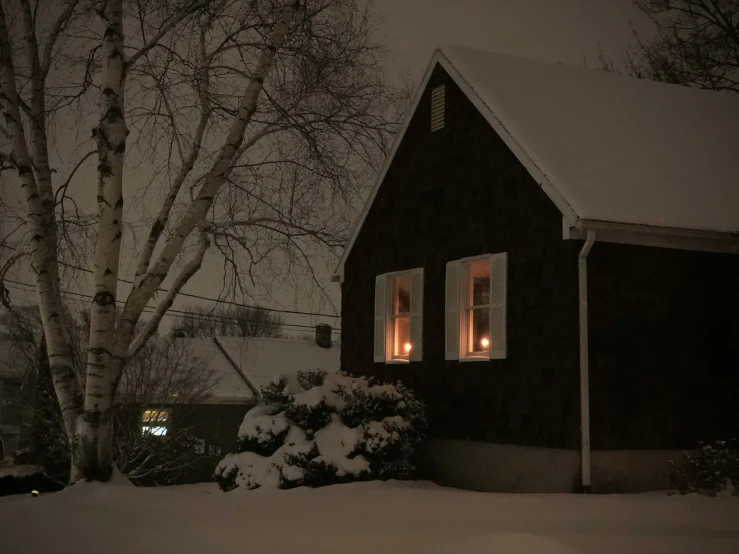 night lights glowing in windows of a cabin in winter