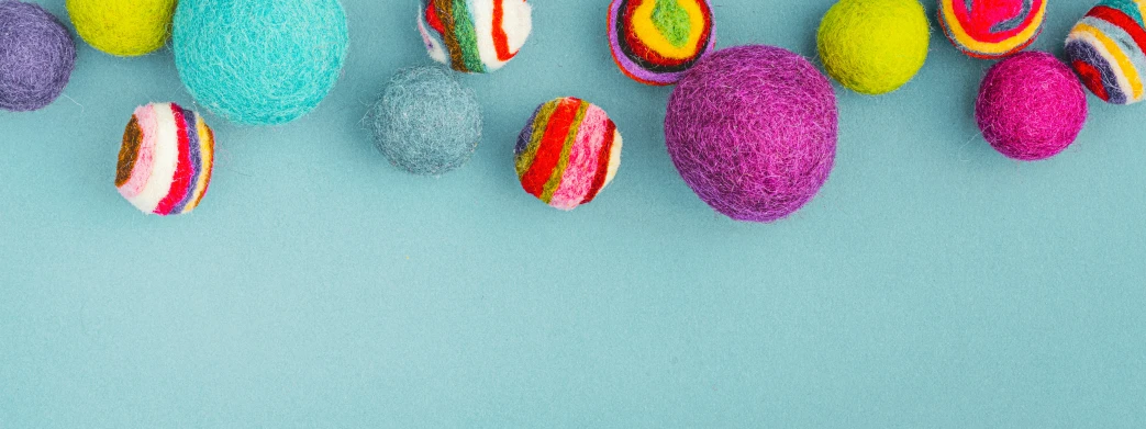 small colorful balls on a blue surface with a green background