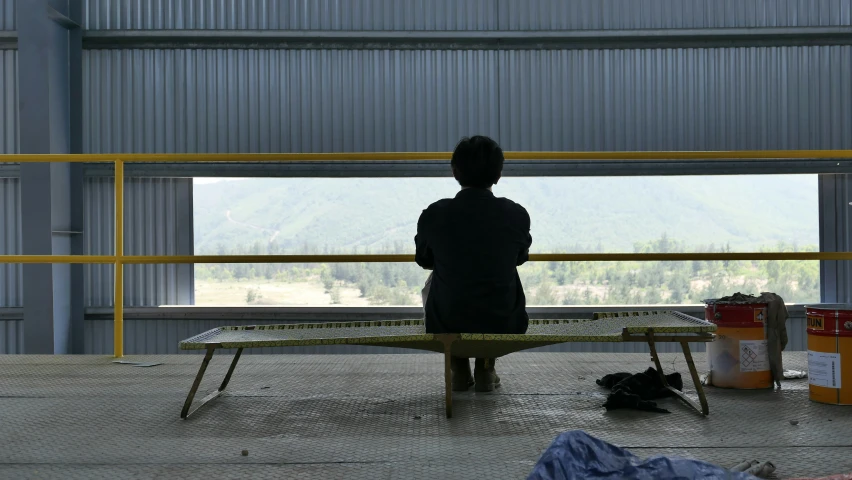 a person sitting on a bench in an empty building