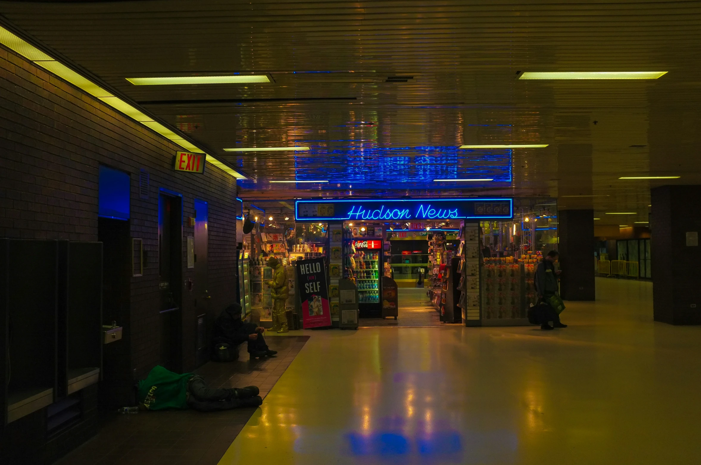 a shopping mall at night with a neon sign