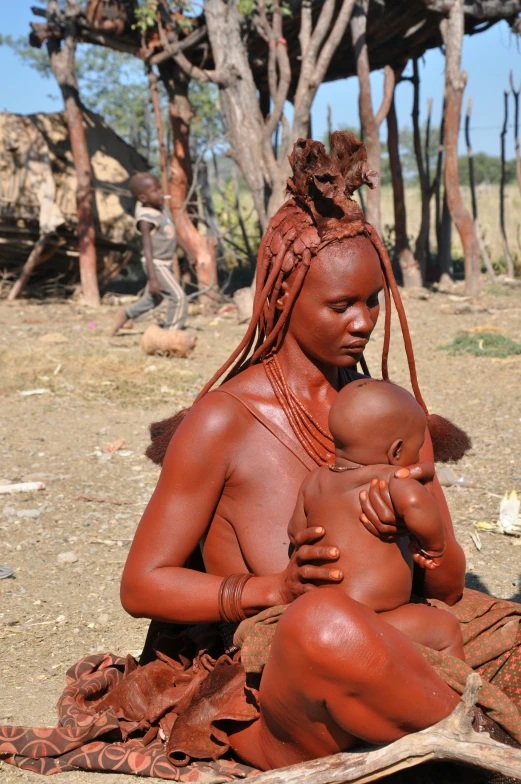 a woman sitting on the ground with a baby