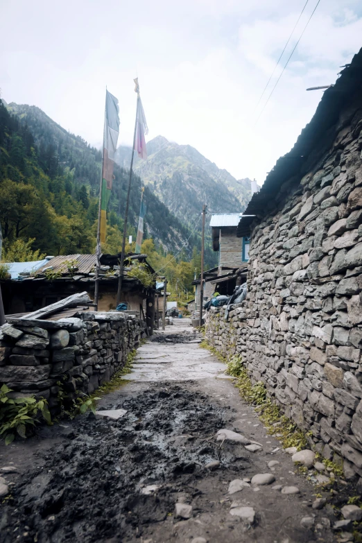 an empty stone walk way leading to small houses