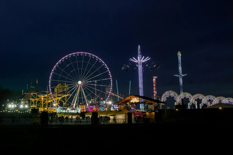 a group of people standing next to a ferris wheel