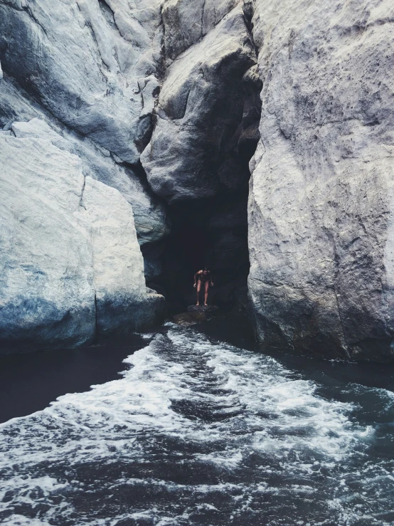 two people swim in the water and one is standing