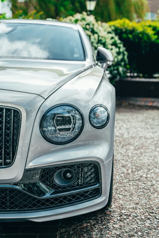 a silver car with white trim sits parked in the driveway