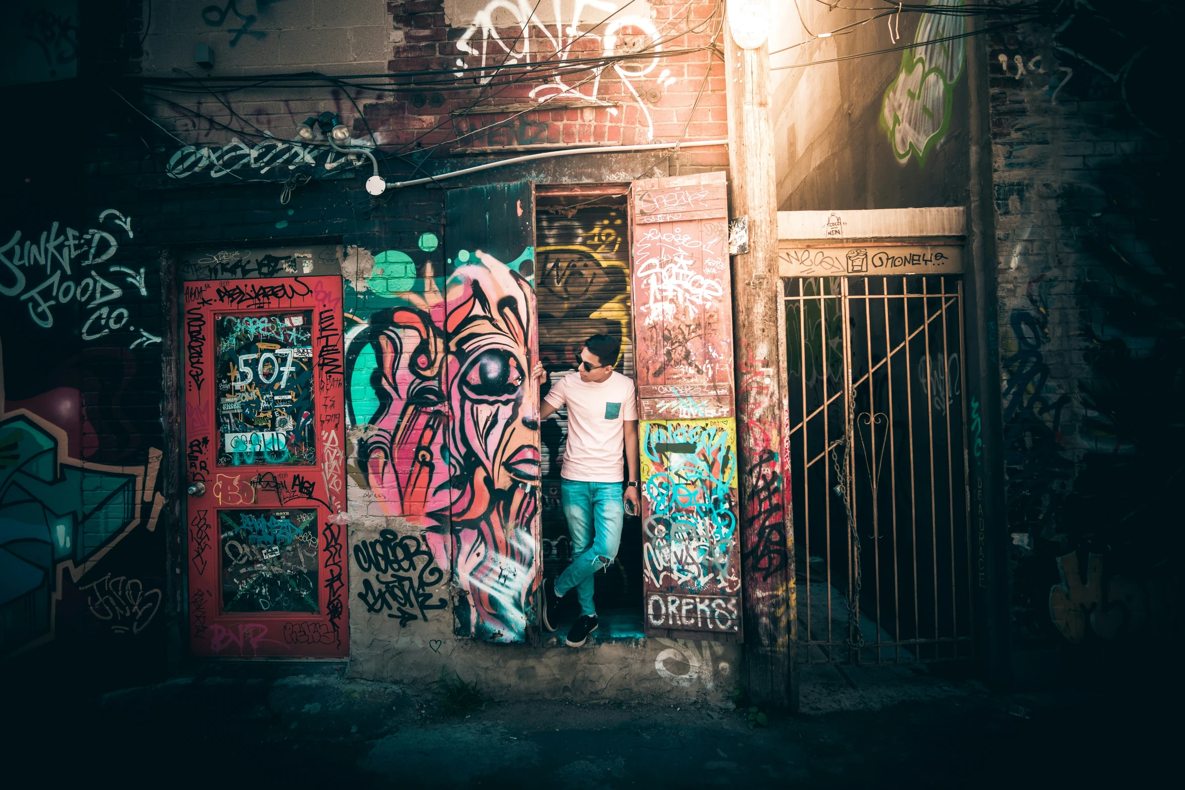 a man standing in a doorway next to some graffiti