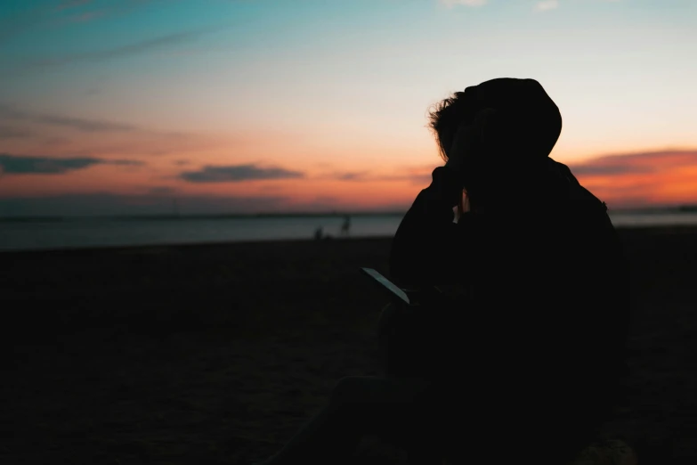 a person in silhouette holding a cell phone