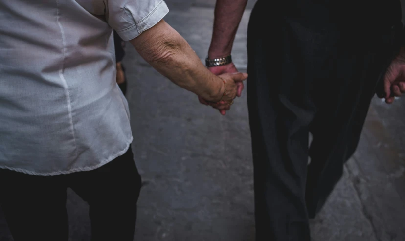 there are two people holding hands on the street