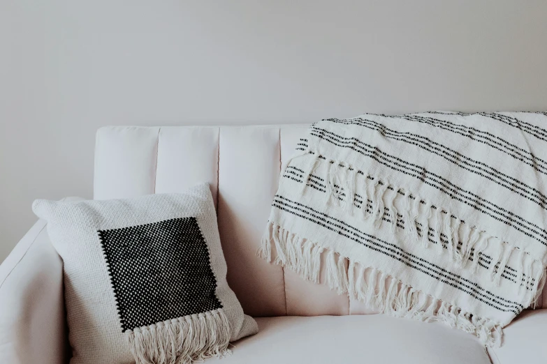 a white couch with a blue and white decorative pillow on it