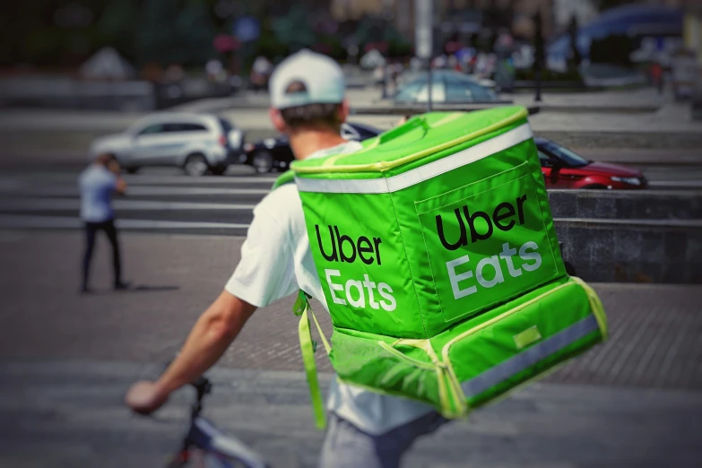 man with green lunchbox on the street in traffic