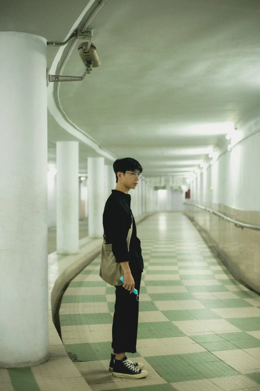 a boy standing in a large long hallway