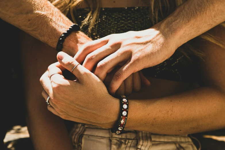 a close up of two people holding hands