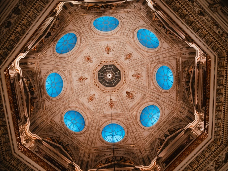 an intricate ceiling in the middle of a large building