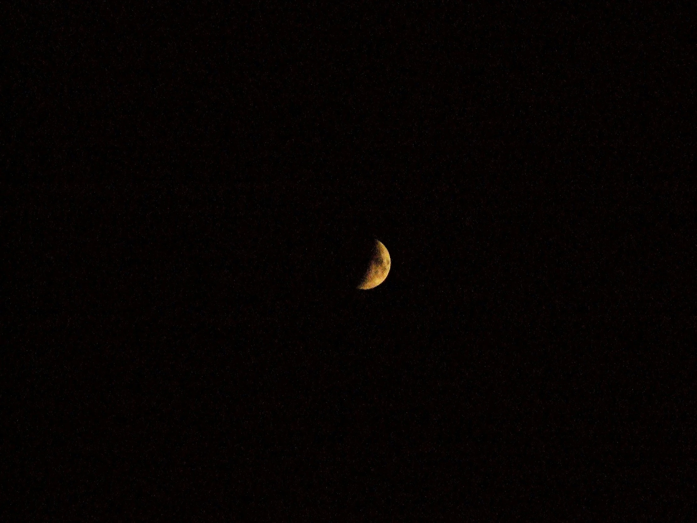 a half moon at night with stars in the sky