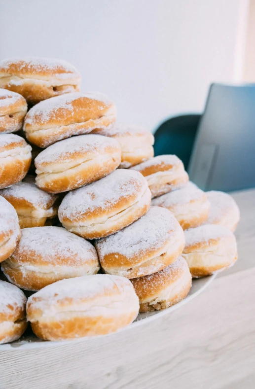 piles of powdered sugar donuts stacked on top of each other