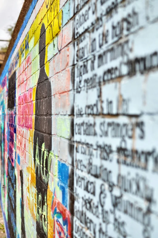 a man walking past a colorful wall and a clock