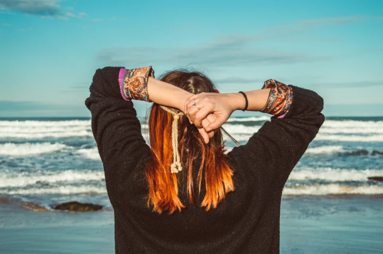 woman with her hair in the wind by the beach